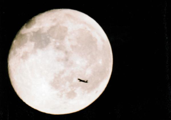 Photo of the moon with jet flying in front of it